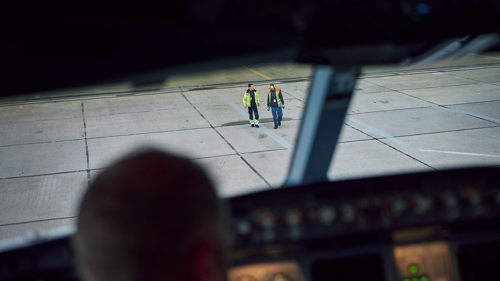 two-satair-employees-on-runway-seen-from-airplane-cockpit.jpg